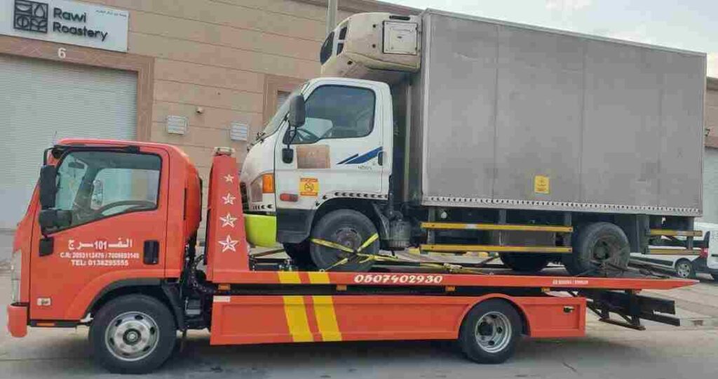 Flatbed tow truck operated by Al Farj-sponsored professional towing service in Al Khobar, providing 24/7 safe vehicle recovery